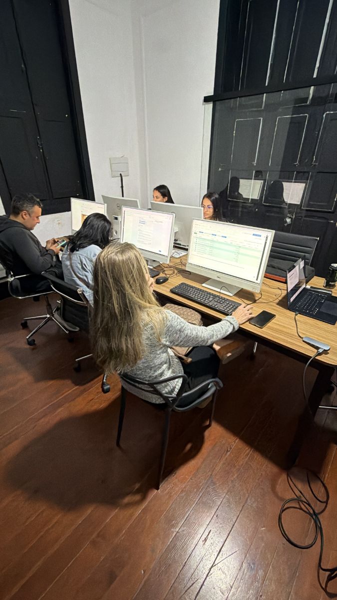 Alunos praticando nos computadores da sala de aula